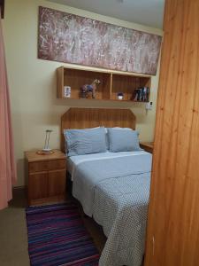 1 dormitorio con 1 cama con cabecero de madera en OKE Apart Hotel en San Lorenzo