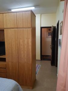 a bedroom with a large wooden closet and a door at OKE Apart Hotel in San Lorenzo