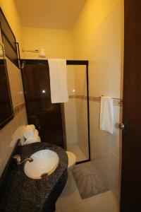 a bathroom with a sink and a toilet and a shower at OKE Apart Hotel in San Lorenzo