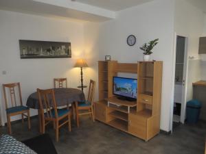 ein Wohnzimmer mit einem Tisch und einem TV sowie ein Esszimmer in der Unterkunft Appartement Thiers in Avignon