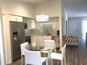 a kitchen with a glass table and white chairs at Oasis Villa Retreat in Bradenton
