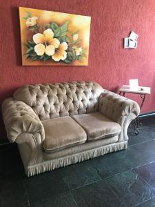 a couch in a room with a painting on the wall at Apartamento Ano Bom in Barra Mansa