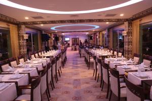 un comedor con mesas y sillas con manteles blancos en Buyuk Osmaniye Hotel, en Osmaniye