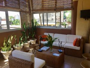 a living room with chairs and tables and windows at Bolo Residence Douala in Douala