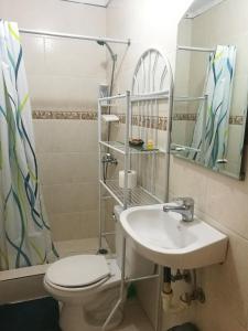 een badkamer met een wastafel, een toilet en een spiegel bij El Pueblito,al lado de Playa Dorada in San Felipe de Puerto Plata