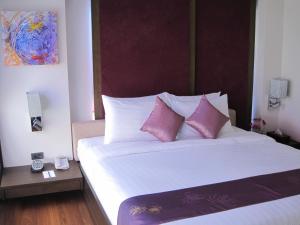 - une chambre avec un grand lit et des oreillers roses dans l'établissement Paradiso Boutique Suites, à Bangkok