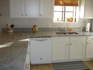 una cocina con armarios blancos y fregadero en Grant's Condo in The Greens en Branson