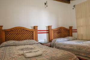 a bedroom with two beds with a shoe on the bed at MESÓN DE LOS ÁNGELES in Comitán
