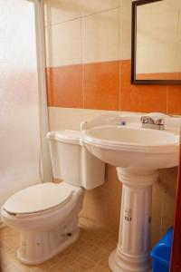 a bathroom with a white toilet and a sink at MESÓN DE LOS ÁNGELES in Comitán de Domínguez