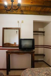 a television sitting on a table in front of a mirror at MESÓN DE LOS ÁNGELES in Comitán de Domínguez