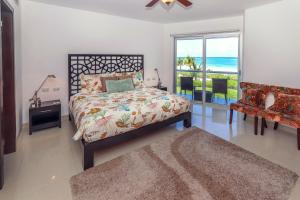 1 dormitorio con 1 cama y vistas al océano en Condo Corazon - True Beachfront Golf Course Condo - At Mareazul, en Playa del Carmen