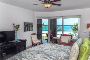1 dormitorio con 1 cama con ventilador de techo y el océano en Condo Corazon - True Beachfront Golf Course Condo - At Mareazul, en Playa del Carmen