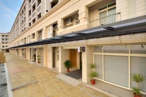 un edificio con puertas y plantas en una calle en Hoya Resort Hotel Chiayi, en Minxiong