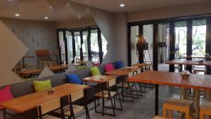 a restaurant with tables and chairs with colorful pillows at Wanadu Residence in Tangerang