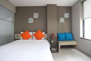- une chambre dotée d'un lit avec des oreillers orange et bleu dans l'établissement Wanadu Residence, à Tangerang