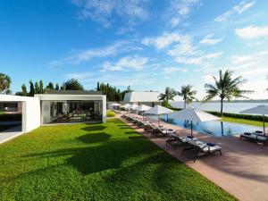 a resort with a pool and chairs and a lawn at The Bale Phnom Penh by LifestyleRetreats in Phnom Penh