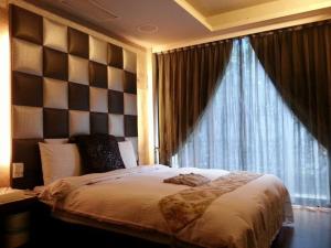 烏來區的住宿－51溫泉，一间卧室设有一张大床和一个窗户。