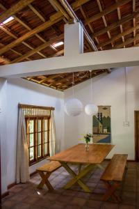 een eetkamer met een houten tafel in een kamer bij The Pepper Cottage in Gomagoda