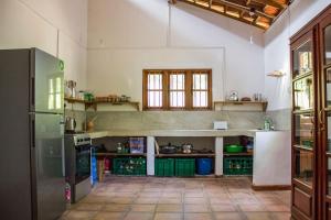 a large kitchen with green cabinets and a refrigerator at The Pepper Cottage in Gomagoda