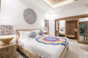 een slaapkamer met een groot bed en een spiegel bij Ambermoon Villa 2 in Seminyak +22 foto's