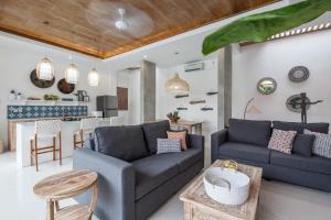 een woonkamer met twee blauwe banken en een keuken bij Ambermoon Villa 2 in Seminyak