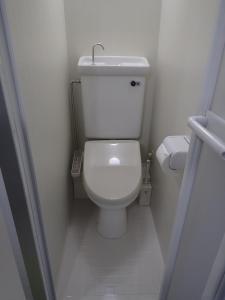a small white toilet in a small bathroom at Park Avenue Kokubunji in Koganei +3 photos