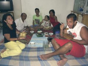 Un groupe de personnes assises autour d'une table et mangeant de la nourriture dans l'établissement Jeges Homestay, à Senggigi