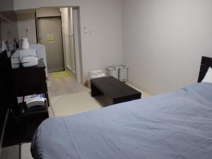 Koganei的住宿－國分寺大道公園公寓，一间医院间,配有床、书桌和浴室