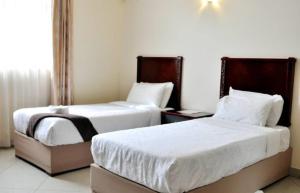 two beds sitting next to each other in a room at Pensao Marhaba Residencial in Maputo