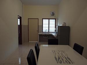 a room with a table and chairs and a kitchen at Golden Hill Double Storey Homestay at Night Market in Cameron Highlands