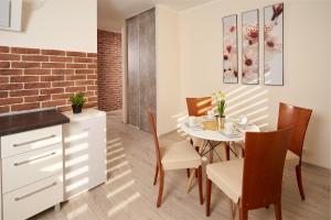 Una cocina y un comedor con mesa y sillas. en Apartament Winnica Centrum, en Zielona Góra