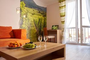 una sala de estar con una mesa con copas de fruta y vino en Apartament Winnica Centrum, en Zielona Góra