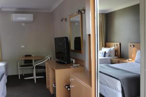 a hotel room with two beds and a television at El Toro Motor Inn in Warwick Farm