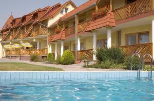 a hotel with a swimming pool in front of it at Erika Pension in Keszthely