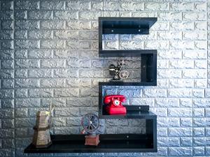 a black shelf against a brick wall with a red bag at INg Hostel in Hualien City