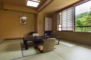 Zimmer mit einem Tisch, Stühlen und einem Fenster in der Unterkunft Takamiya Hotel Hammond in Zao Onsen