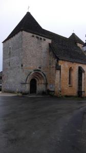 un antiguo edificio de ladrillo con una puerta grande en Au Tilleul, en Archignac