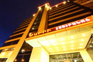 a tall building with a neon sign on it at New Nairi Hotel in Yerevan