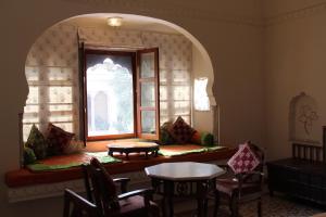 a room with a window and a table and chairs at Dera Mandawa in Jaipur