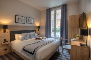 a hotel room with a large bed and a large window at Hotel Paganini in Nice