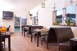 a dining room with tables and chairs and windows at Villa Rosa in Stronie Śląskie