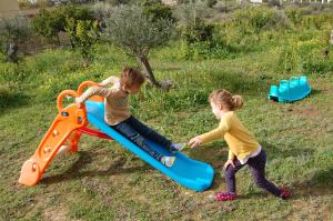 two children playing on a slide in a field at Marianna Holiday Home in Nafplio