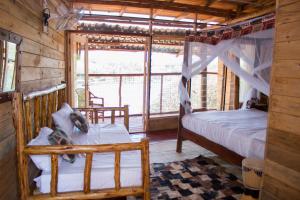 a bedroom with two beds and a window in a cabin at Living Waters Resort in Jinja