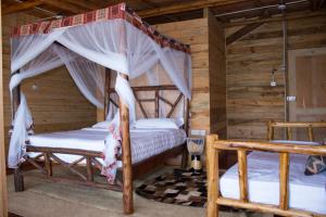 1 dormitorio con 2 camas en una cabaña de madera en Living Waters Resort en Jinja