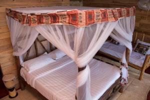 a bed with a canopy in a room at Living Waters Resort in Jinja