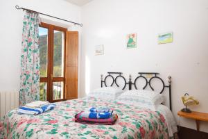 - une chambre avec un lit doté d'un couvre-lit floral et d'une fenêtre dans l'établissement Bed & Breakfast De Contra, à Villetta Barrea