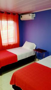 una camera con due letti e pareti rosse e blu di Miss Leila a San Andrés