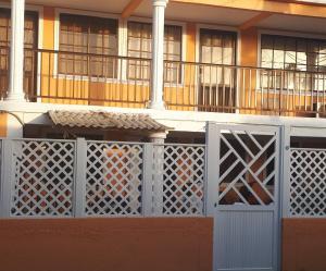 a building with a white gate and a balcony at Miss Leila in San Andrés
