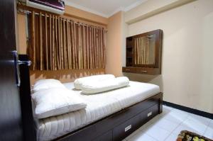 Un dormitorio con una cama con almohadas blancas. en Standard Room Apartemen, low budget but nice, en Yakarta