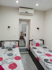 1 dormitorio con 2 camas y un pasillo con ventana en Guest House Ivanovi, en Banya